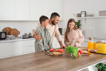 Cute little children with their father preparing sandwiches at home
