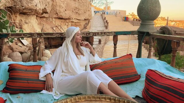 A beautiful girl in traditional clothes rests in a cafe in Egypt