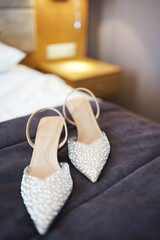 Wedding sandals of the bride on the bed. Preparation for the wedding.