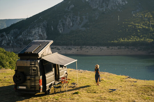 A camper van by a lake near a mountain, evoking tranquility and adventure in nature