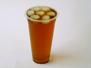 A refreshing iced tea served in a convenient plastic cup. A classic iced tea, served in a disposable clear plastic cup. Indonesia classic beverage