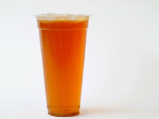 A refreshing iced tea served in a convenient plastic cup. A classic iced tea, served in a disposable clear plastic cup. Indonesia classic beverage