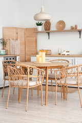 Stylish interior of kitchen with candles on dining table