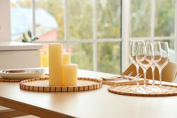 Candles on tray and glasses on table in modern kitchen