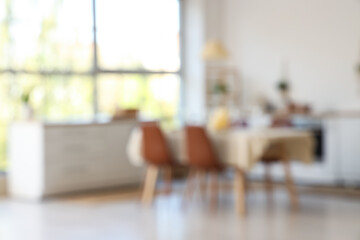 Served dining table with candles in kitchen. Blurred view