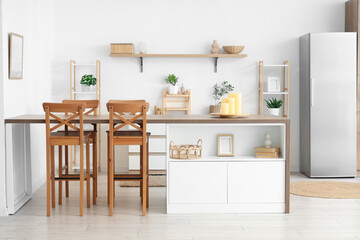 Wooden table with candles in modern kitchen
