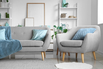 Comfortable sofa, armchair and houseplant in interior of living room