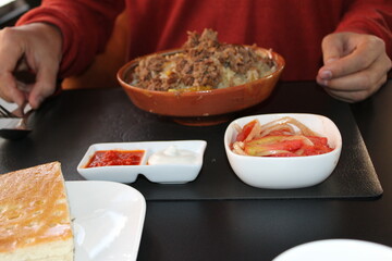 A photograph of a man enjoying lunch, with a plate of pilaf and fresh salads on the table, capturing a warm, cozy moment of eating.