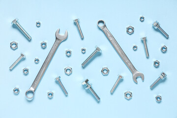 Tap bolts, chrome nuts and wrenches on blue background