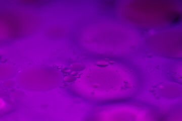 Colorful oil bubble patterns floating on water surface.