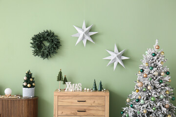 Interior of living room with Christmas trees, drawers and stars