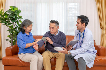 a nurse or doctor using digital tablet to teach senior wife measuring blood pressure an old man patient at home,elderly health care,personal care services,home health care