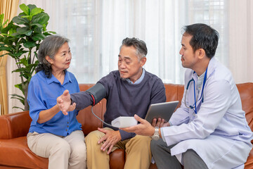 Obraz premium a nurse or doctor using digital tablet to teach senior wife measuring blood pressure an old man patient at home,elderly health care,personal care services,home health care