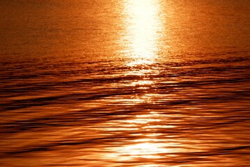 Blurred sunlight reflection on water surface with water waves for background backdrop 