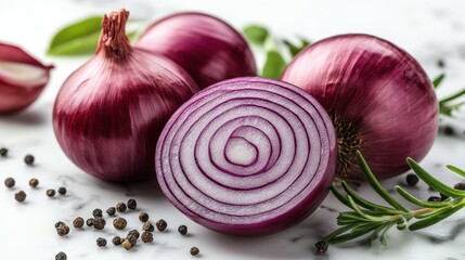 Vibrant red onions displayed alongside sprigs of rosemary and black peppercorns on a marble surface, highlighting their freshness and readiness for cooking