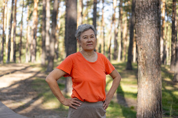 Portrait of an elderly Asian woman in sportswear in a park. sporty pensioner