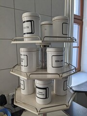 Traditional upright bottles containing pharmaceutical raw materials in a rotary container, used for precise laboratory drug preparations in the pharmacy-pharmaceutical technology