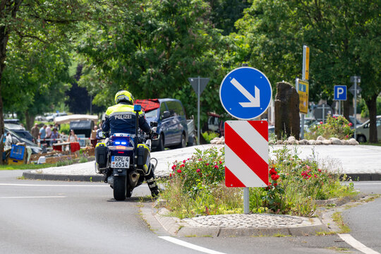 A german Police Motorcycle at Roundabout with flowers and a lane direction sign in Uerzig, Germany - Jul 19, 2024