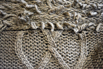 Women's clothing, stylish knitwear made of natural woolen dense threads. Beautiful patterns, braids, nice, soft braided woolen fabric.