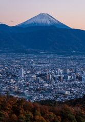 甲府市千代田湖ハイキングコースから甲府市の街並みと夕焼けの富士山