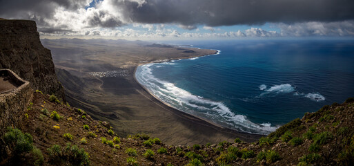 View on Playa de Famara, Lanzarote, from the cliffs, Timanfaya Nationalpark in the background