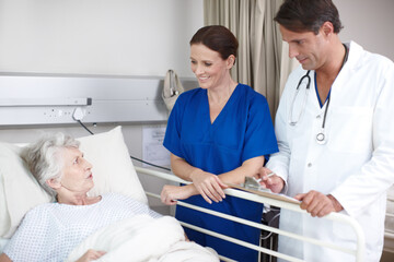Obraz premium Medical, team and senior patient in hospital bed for healthcare results, surgery information and checkup notes. Elderly woman, nurse and doctor with clipboard in clinic for health support or recovery