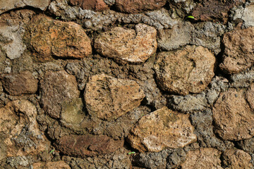 A wall made of rocks and dirt. The wall is brown and gray