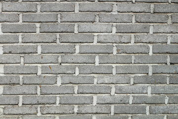 Close-up view of a textured gray brick wall.