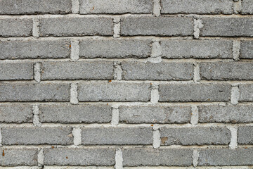 Close-up view of a textured gray brick wall.