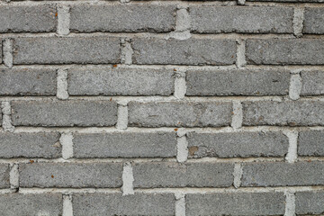 Close-up view of a textured gray brick wall.