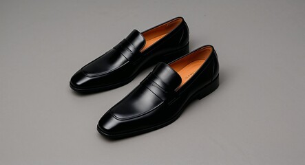 Mens formal black loafers with a sleek leather exterior and classic slip on design gray background 