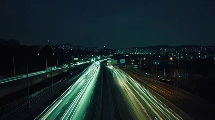 A night time view of a highway with light trails from the cars.