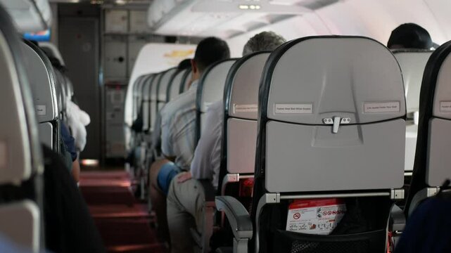 view inside airplane aircraft through aisle pathway on the plane to seat inside aircraft while airplane flying climbing into sky full with passenger.travelling vacation holiday transportation