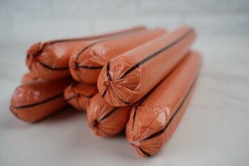 Raw meat sausages. Sausages in pink transparent artificial shell with black stripes