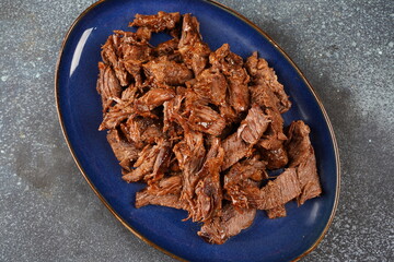Beef stew in a cast iron skillet. Sliced pieces of braised beef