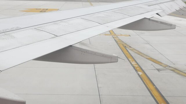 view to rear wing of airplane while aircraft pushback from gate terminal view to ground in sunny summer day while plane ready to departure to travel for holiday vacation