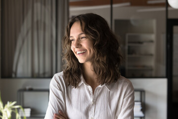 Head shot portrait happy young professional woman looking away with smile. Successful office...