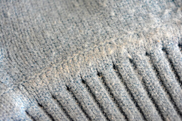Knitted products, light blue women's woolen sweater with interesting patterns, knitting in the form of a braid, gathered elastic, different weaves and stitching.