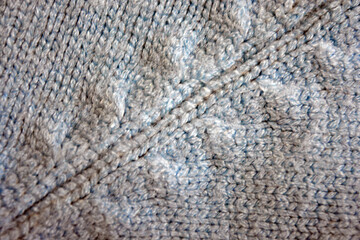 Knitted products, light blue women's woolen sweater with interesting patterns, knitting in the form of a braid, gathered elastic, different weaves and stitching.