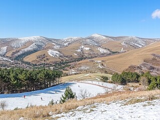 Snowy Landscape with Skiers and Mountains Under Clear Blue Sky