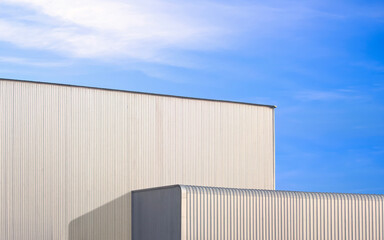 Large industrial factory building with exterior corrugated metal wall against blue sky background, Industry architecture design in minimal style