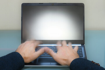 Fototapeta premium hands of a man working on laptop, typing on the keyboard, working on a notebook, screen of a mobile computer