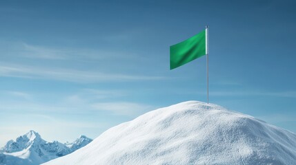 Fototapeta premium Green flag stands proudly atop a snowy mountain peak under a clear blue sky