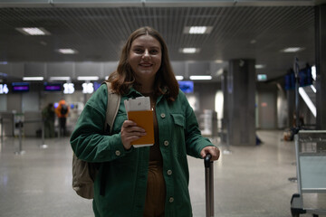 International airport terminal. Happy attractive Caucasian 30s woman traveler with backpack at the modern airport terminal. Tourist journey trip concept