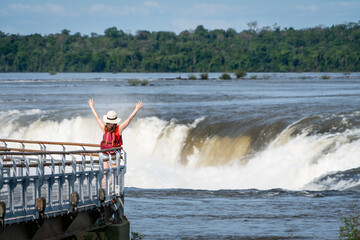 Mujer turista disfrutando del Parque Nacional Iguazú, en Argentina. Contemplando la Garganta del Diablo con los brazos abiertos