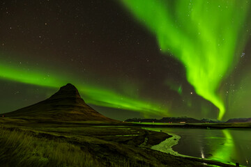Cone shaped Northern lights or aurora borealis over Kirkjufell in October autumn season in...