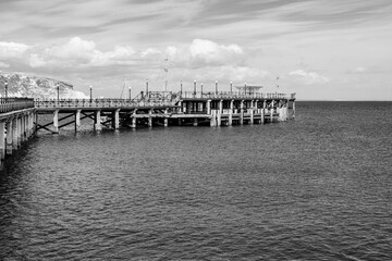 Swanage, Dorset, England, UK - 18 April 2021: Swanage Pier, Victorian pier on the eastern coast of the Isle of Purbeck in black and white
