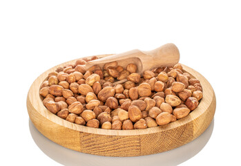 Several hazelnuts with wooden bowl, close-up, isolated on white background.