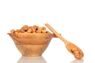 Several hazelnuts with wooden bowl, close-up, isolated on white background.