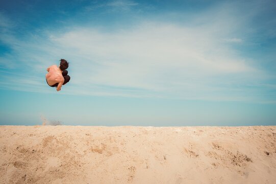 person jumping on the beach